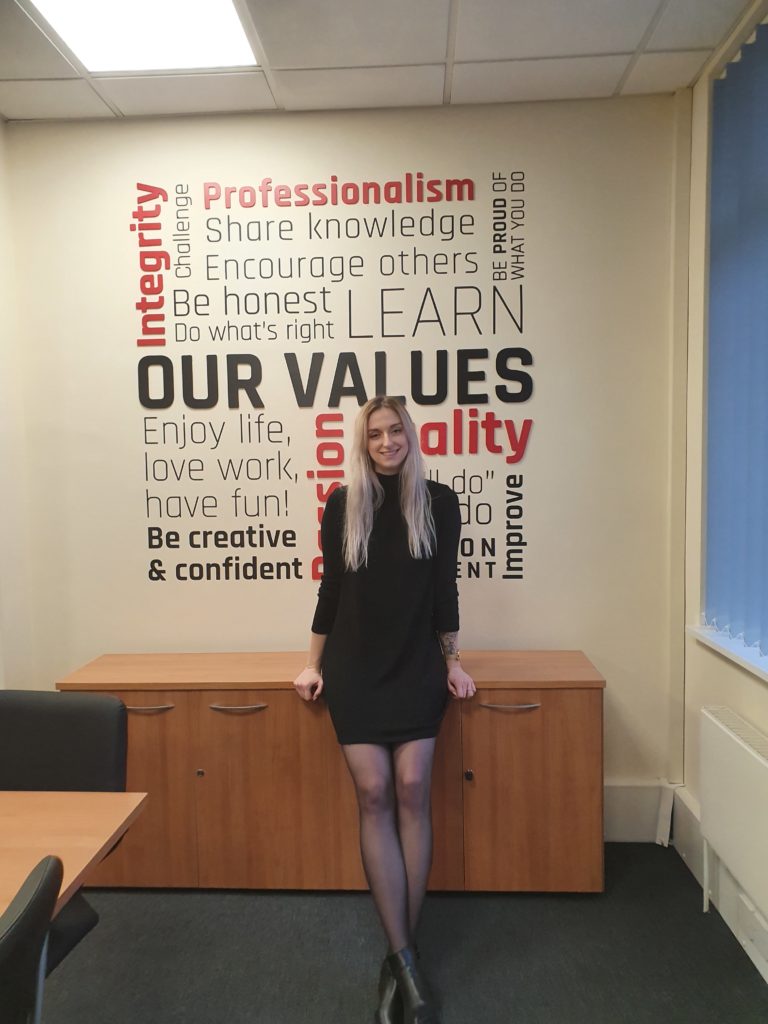 Senior Researcher Emily Damerell pictured in front of SafeLane company values